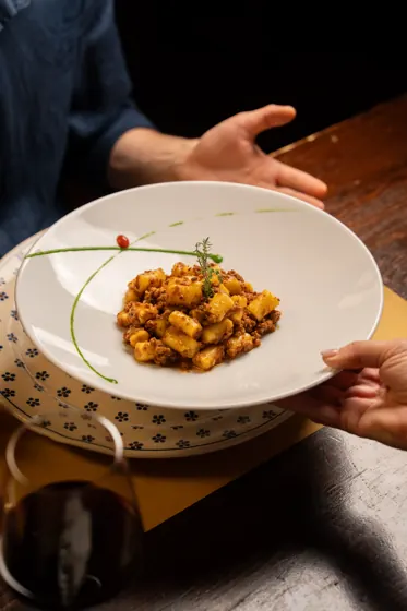 Pasta al ragù presentata al tavolo